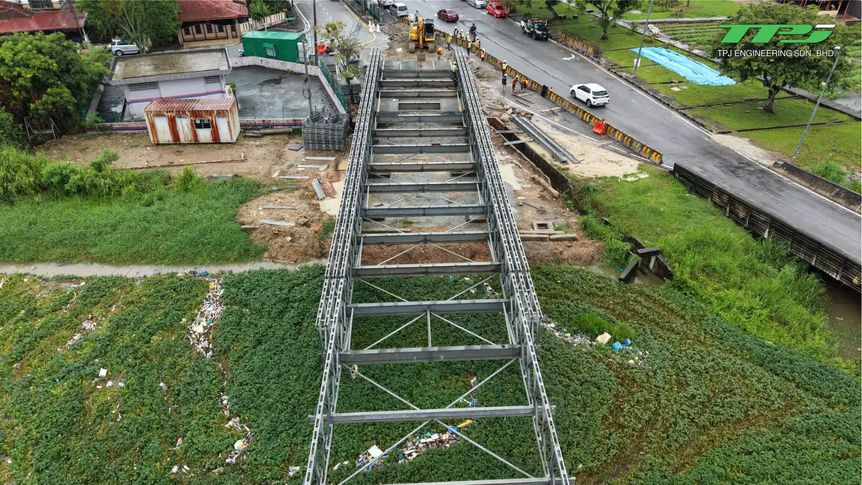 Top-down view of the Bailey bridge deck and steel truss installation across the riverside crossing in Seberang Jaya.
