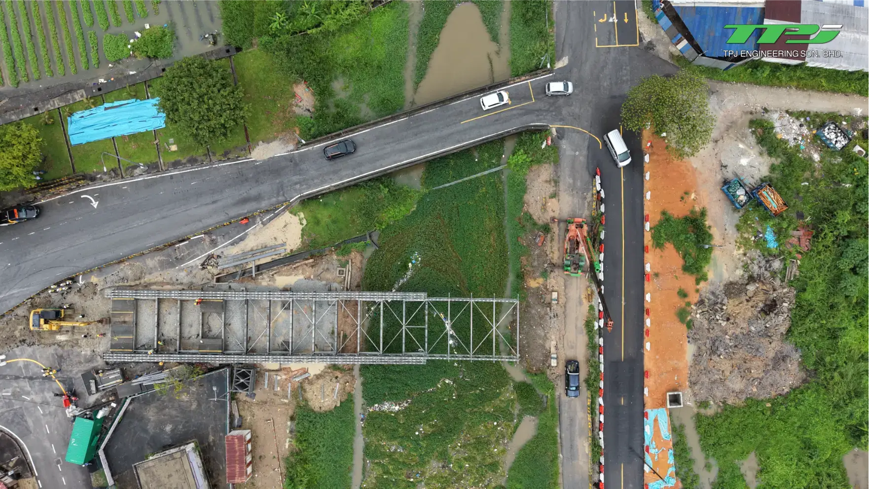 Top-down aerial view of the bridge construction footprint and temporary crossing beside the road in Seberang Jaya.