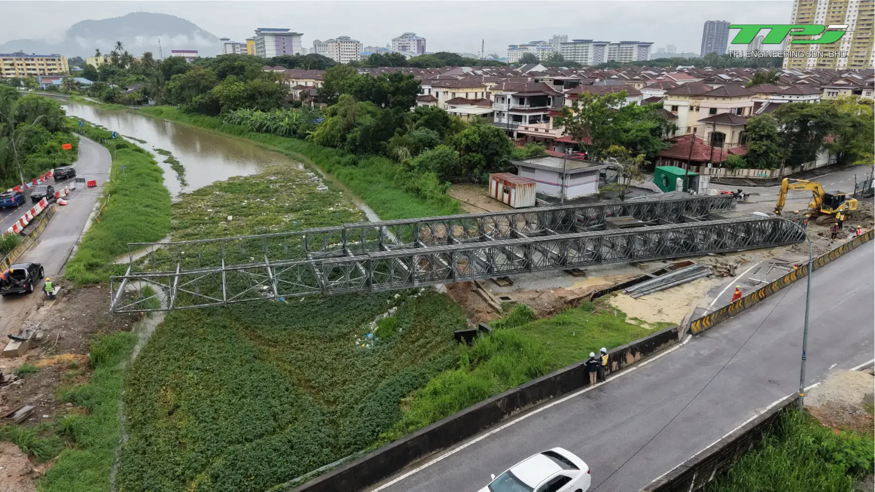 Wide aerial view of the temporary Bailey bridge spanning the river and the surrounding Seberang Jaya neighbourhood.