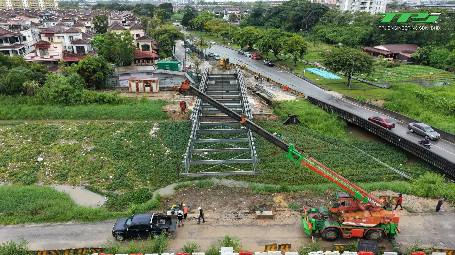 Aerial view of an excavator and crane working on the Bailey bridge approach beside the road in Seberang Jaya.