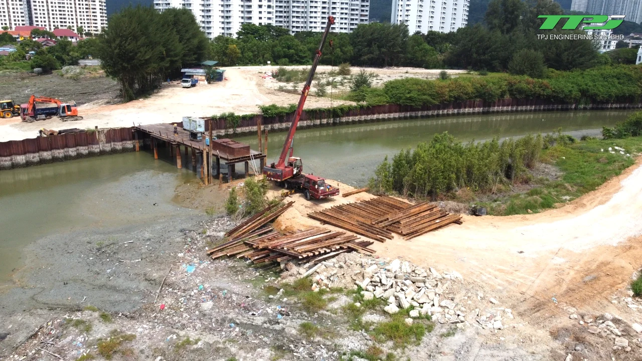 Crane and stacked steel sheet piles beside the Water Body A channel at Gurney Bay