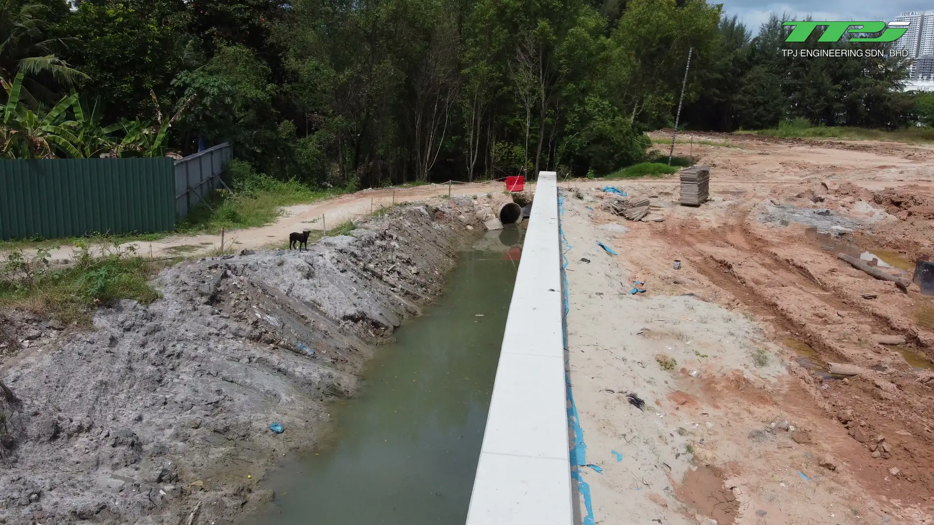 Perimeter excavation and stacked materials beside the Water Body A boundary wall