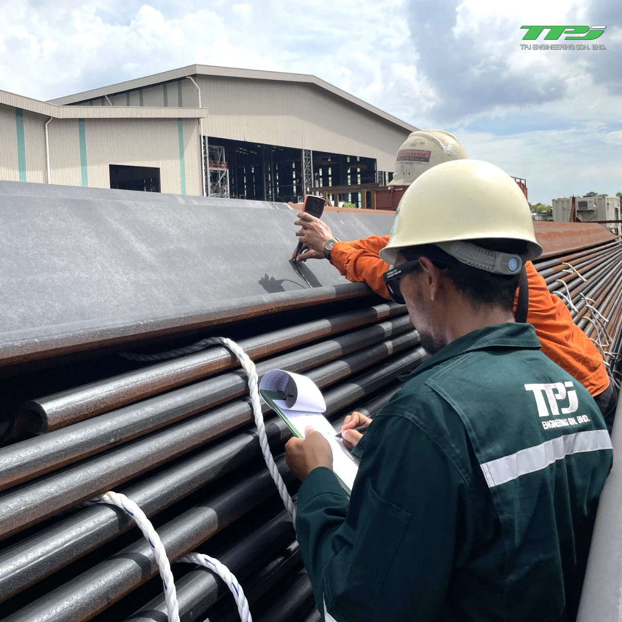 Personnel inspecting stacked steel sheet-pile sections for Water Body A reclamation works