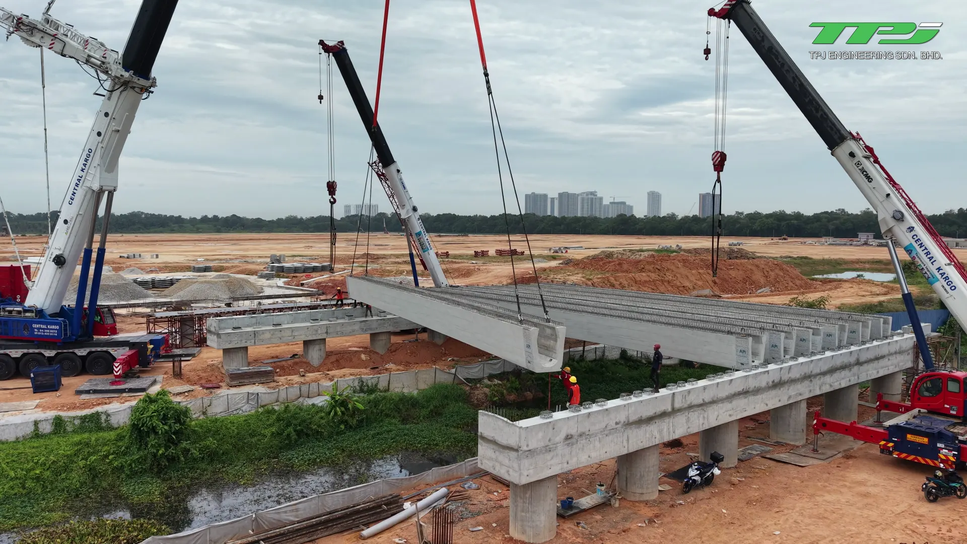 Suspended precast U-beam being positioned beside installed beams and concrete supports at Batu Kawan, Penang.
