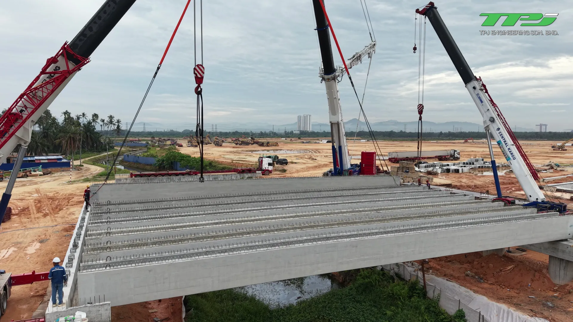 Close aerial view of installed precast U-beams, crane booms and lifting slings at the Batu Kawan bridge site.
