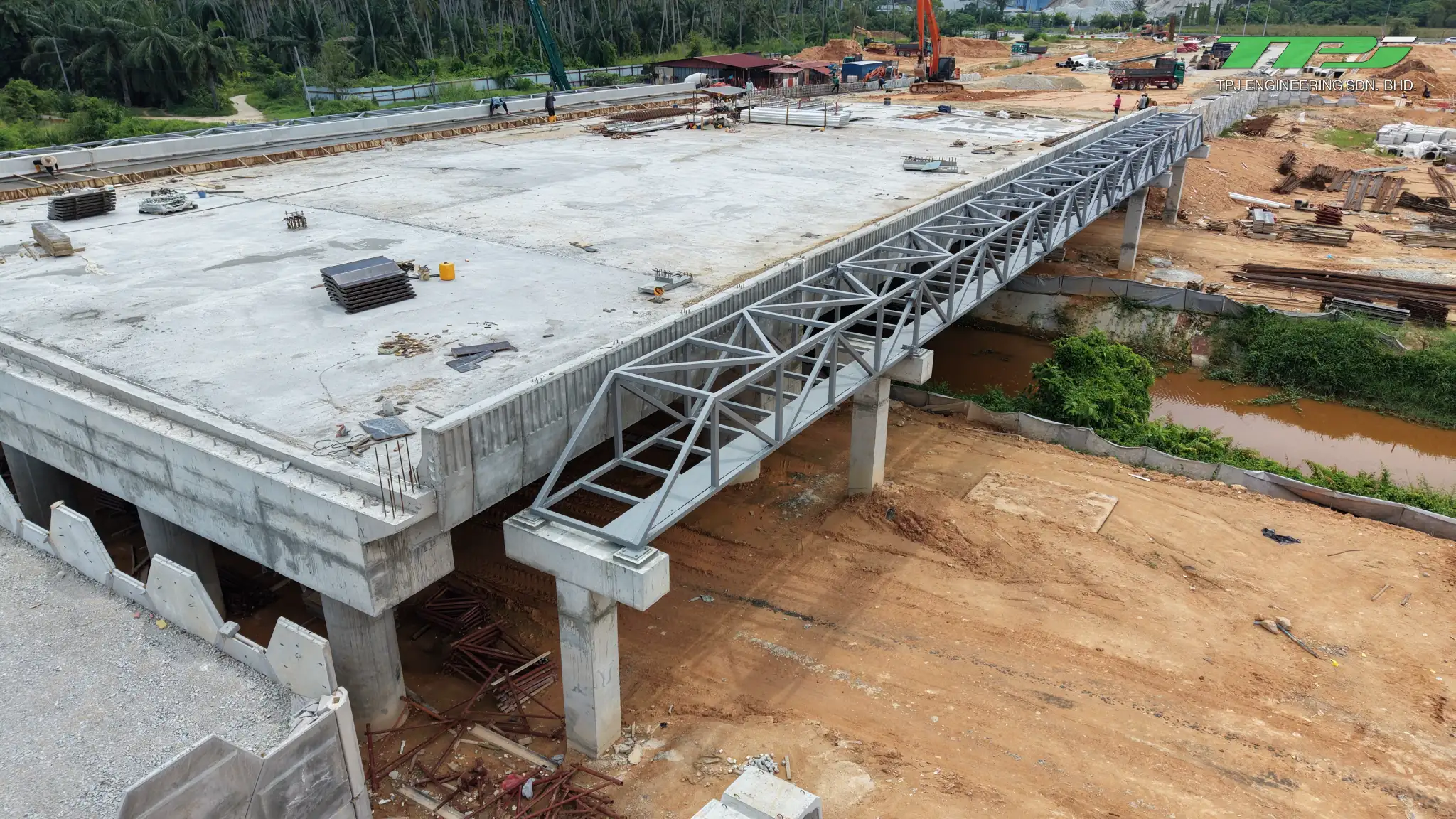 Side view of the Batu Kawan concrete bridge deck and supporting columns, with a temporary steel gantry above.