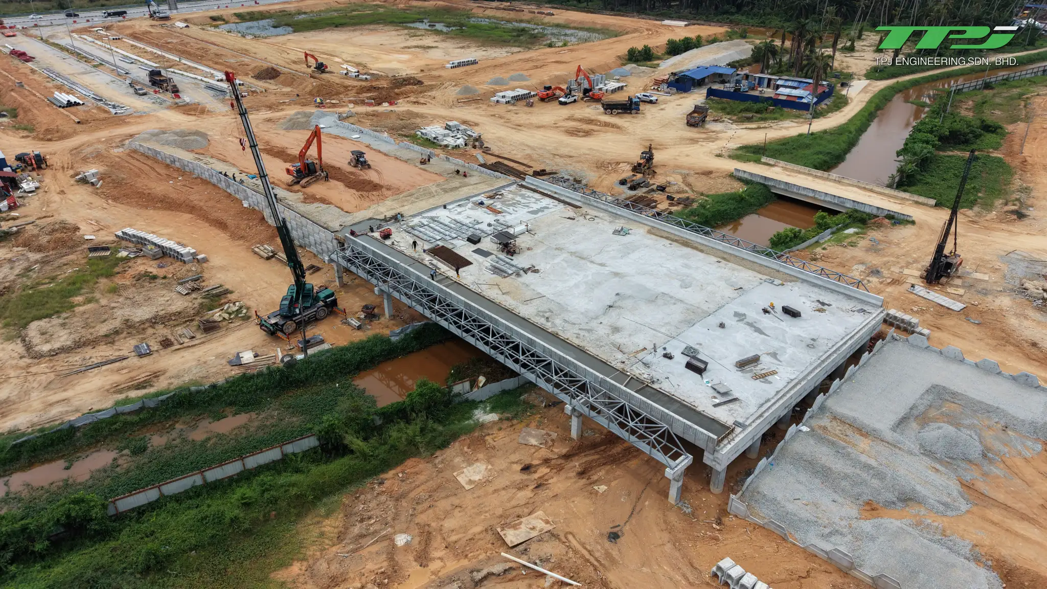Aerial view of the Batu Kawan bridge deck, temporary steel gantries, crane and earth approaches.